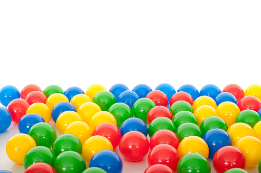 Colorful pet toys balls on green background close up