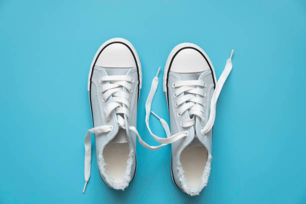 istock blue sneakers with white laces on a blue background. 1319937861