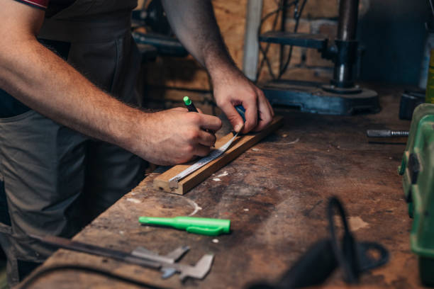 istock Anonymous Carpenter Measuring a Piece of Wood in his Workshop 1319938029