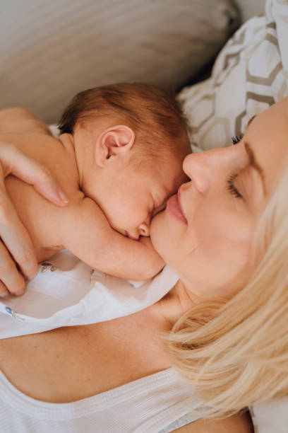 istock Bonding With Newborn: Mother Lying With Baby Girl 1319939999