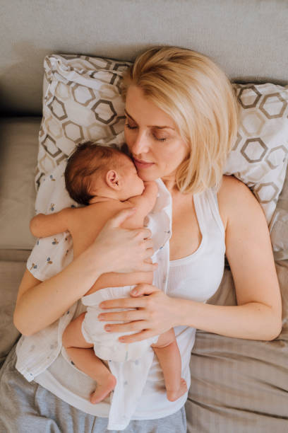 istock Bonding With Newborn: Mother Lying With Baby Girl 1319940010