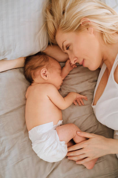 istock Bonding With Newborn: Mother Lying With Baby Girl 1319940038