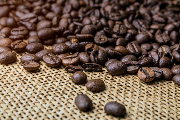 istock Grains of roasted coffee scattered on the table. Macro image. 1319940048