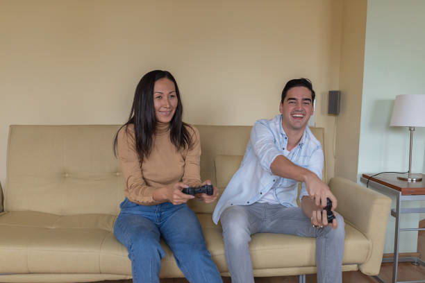 istock Handsome Young Man and his Girlfriend of Chinese Ethnicity are Playing Game Console While Spending Time Together at Home. 1319940158