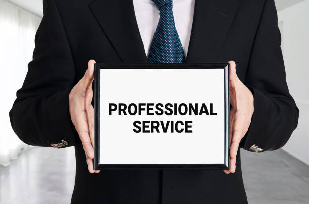 istock Businessman holds a signboard with the message professional service. 1319940230
