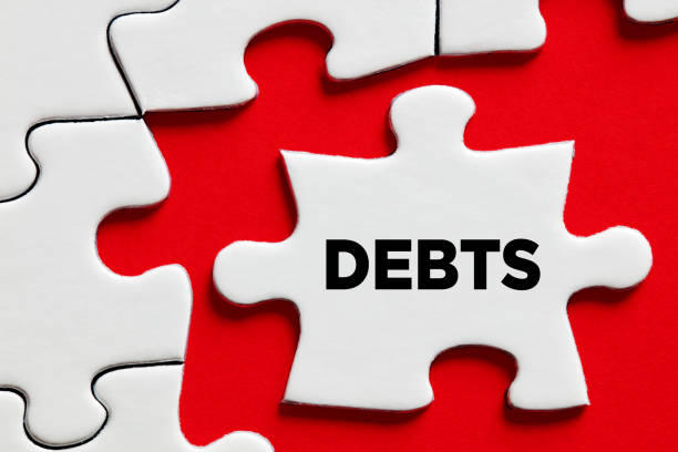 istock The word debts on a puzzle piece with red background. Financial debt 1319941028