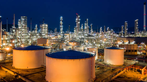 istock Oil refinery plant and industrial factory building construction from engineering technology and steel, Refinery factory oil storage tank and pipeline steel at night. 1319941061