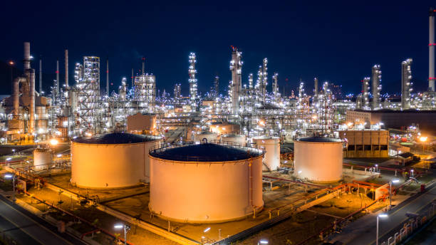 istock Oil refinery plant and industrial factory building construction from engineering technology and steel, Refinery factory oil storage tank and pipeline steel at night. 1319941062