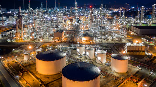 istock Oil refinery plant and industrial factory building construction from engineering technology and steel, Refinery factory oil storage tank and pipeline steel at night. 1319941067