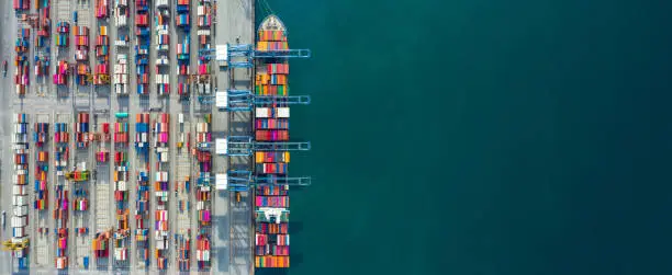 Photo of Aerial view container ship in port at container terminal port, Ship of container ship stand in terminal port on loading, unloading container, Commercial cargo ship in sea port.