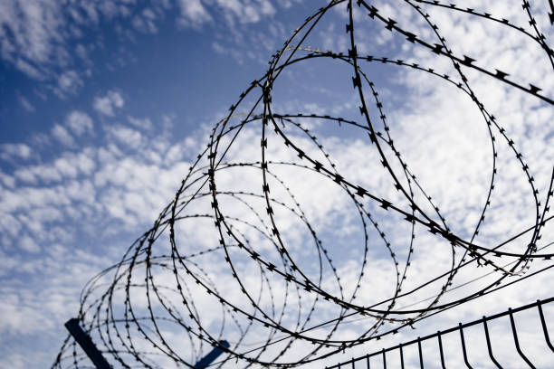 istock barbed wire against the blue sky. protected area. A special, dangerous zone. 1319942109