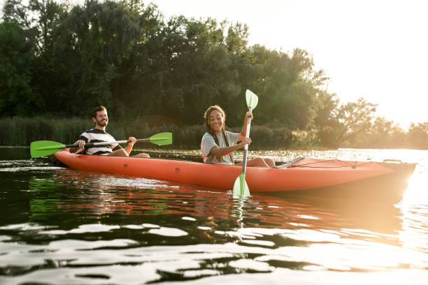 istock Two adventurous young friends kayaking in a river surrounded by the beautiful nature on a summer day 1319942276