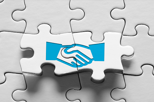 Jigsaw puzzle piece with handshake icon. Business agreement, consensus, strategic alliance or partnership concept.