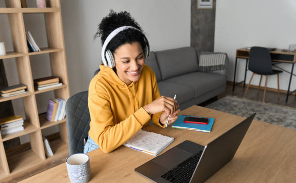 African American female student having video call videoconference on laptop.