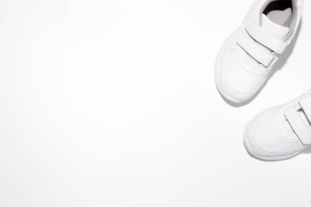 istock mock up two white children's sneakers with Velcro fasteners with copy space isolated on a white background 1319943510