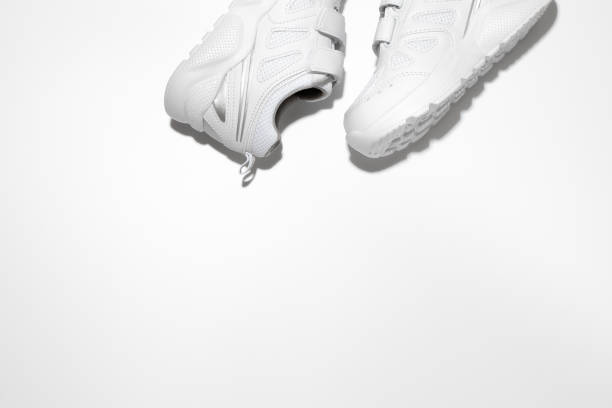 istock flat lay two white unisex sneakers on the side at the top with free space for text isolated on a white background 1319943658