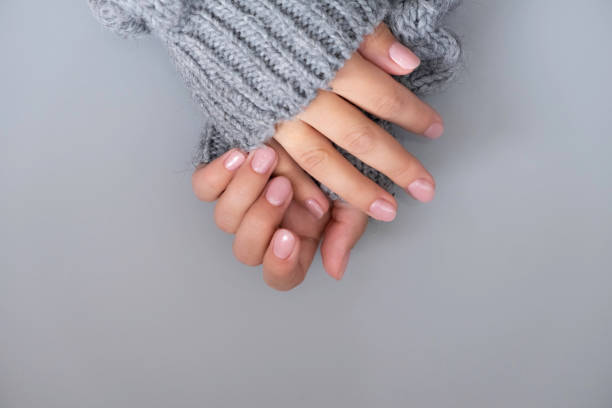 istock beautiful women's hands, with nude manicure on a gray background. 1319943830