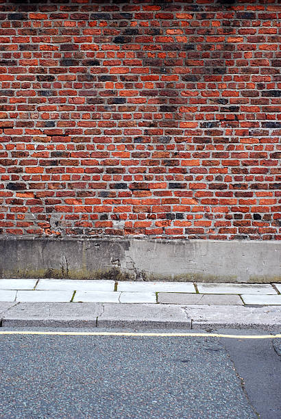 istock Urban background UK - Red brick wall with sidewalk 131994386