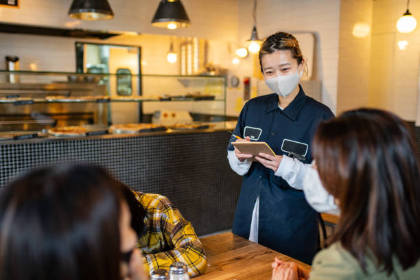 istock Waitress wearing a face mask taking an order in a pizzeria 1319943865