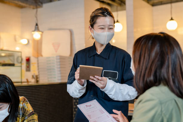 istock Waitress wearing a face mask taking an order in a pizzeria 1319943907