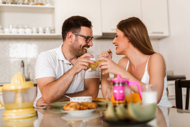 istock Young couple having breakfast at the table in the kitchen. 1319944041