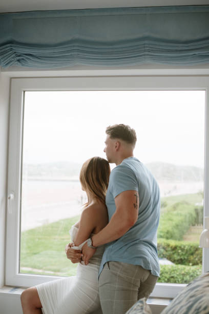 istock Young couple looking through the window 1319945305