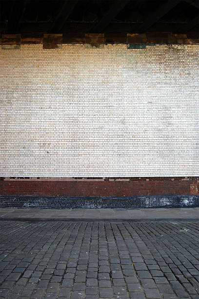 istock Urban background UK - White brick wall with sidewalk 131994535