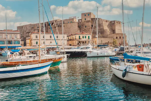 Castel Dell'ovo Or Egg Castle a medieval fortress located in the Gulf of Naples. Famous historical mediterranean coast fortress port. Colorful buildings, yachts and boats, embankment and gulf of Naples