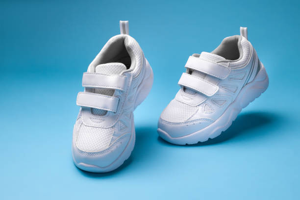 istock macro front view white floating in the air running shoes walking isolated on a blue background 1319947470