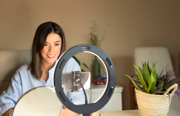 istock Young female blogger doing makeup tutorial video for web channel at home - Happy influencer girl having fun filming with mobile smartphone - Social media and millennial generation lifestyle concept 1319949373