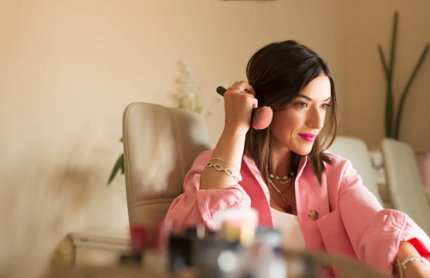 istock Young woman with a makeup brush, getting ready to record a tutorial. Concept of vlogger 1319949403