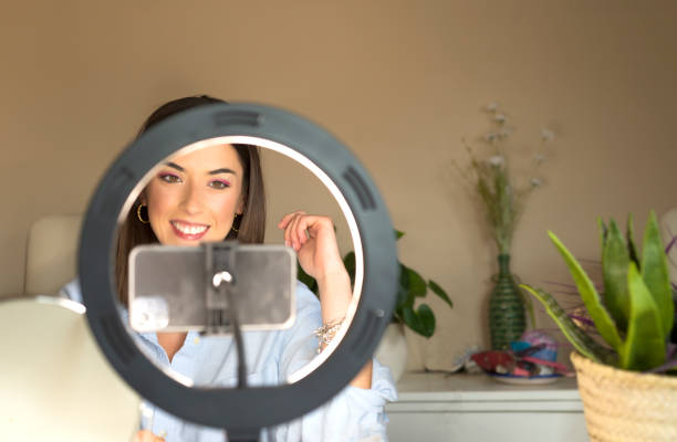 istock Young female blogger doing makeup tutorial video for web channel at home - Happy influencer girl having fun filming with mobile smartphone - Social media and millennial generation lifestyle concept 1319949416