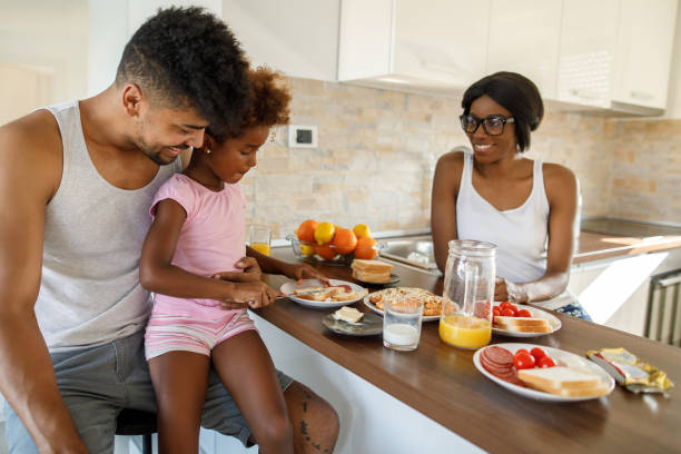 istock Young happy family having breakfast at home 1319950100