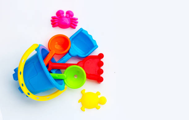 istock Plastic toys, shovels in bucket for sand on white surface. 1319950251