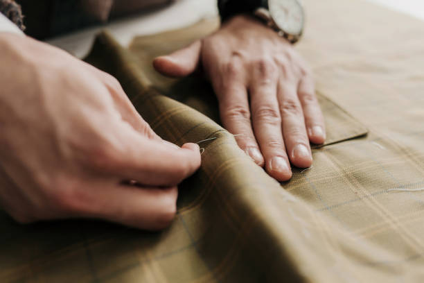 Tailor man working Tailor man working in his tailor shop, individual tailoring clothing design studio stock pictures, royalty-free photos & images