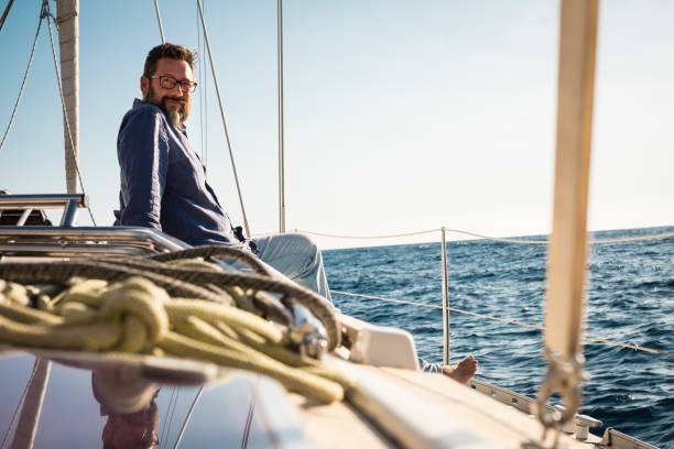 istock Man Sitting On Sailboat In Sea Against Sky 1319955866