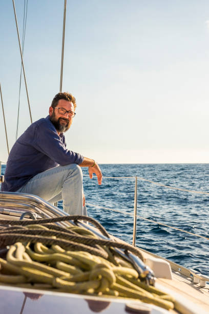 istock Man Sitting On Sailboat In Sea Against Sky 1319955867