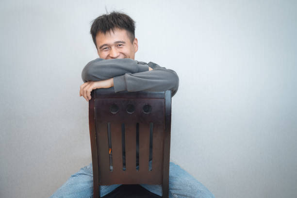 A happy boy sitting on a chair in a clean and tidy environment