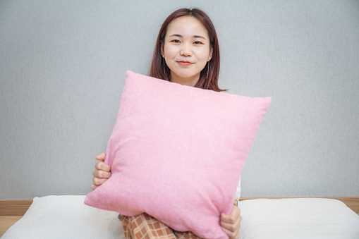 A girl sitting on the ground with soft cushions in a clean and tidy environment