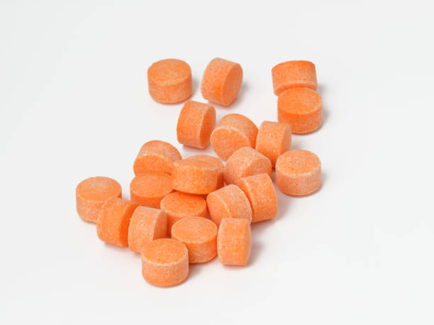 istock orange pills on white background, vitamin C 1319958016