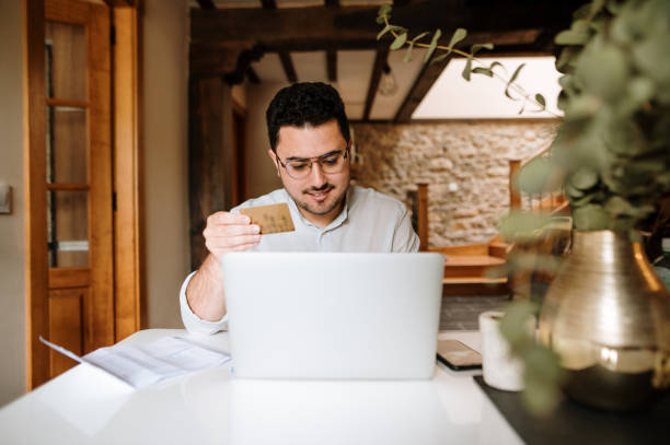 istock Young man buying online with a credit card 1319959901