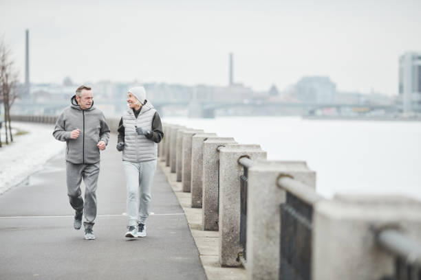 istock Active senior couple running along riverside 1319959943