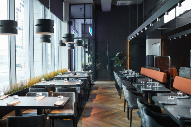 istock Rows of restaurant tables and chairs in gray room 1319959946