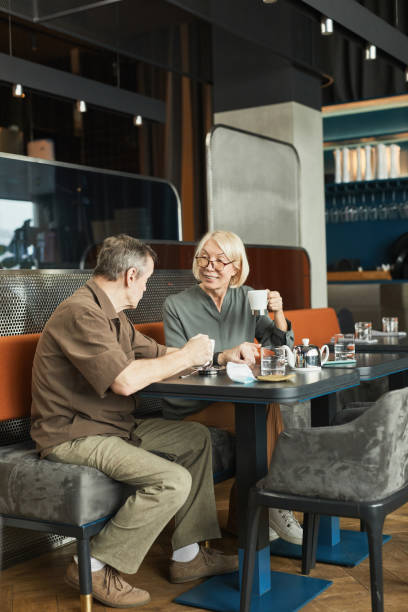istock Positive senior man talking to friend in cafe 1319959982