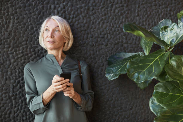 istock Content senior woman checking message on phone 1319960018
