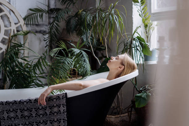 istock Young woman taking bath in cozy bathroom 1319960145