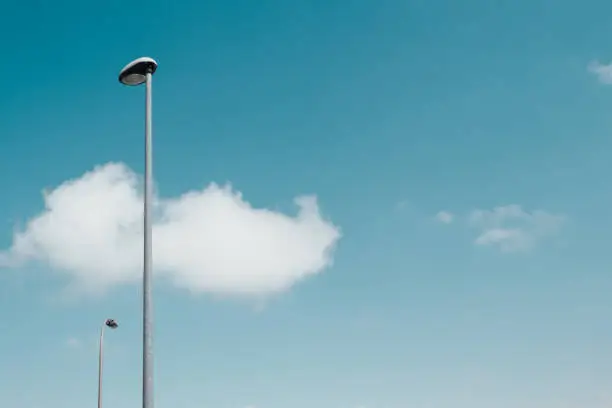 Streetlights with turquoise blue sky with some clouds