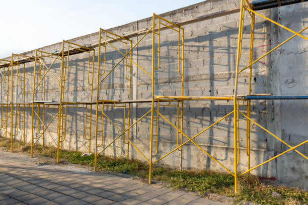 istock Extensive scaffolding providing platforms for work in progress on a new wall block. Modern house wall construction with scaffold pole platform. part of modern scaffolding at a construction site. 1319963028