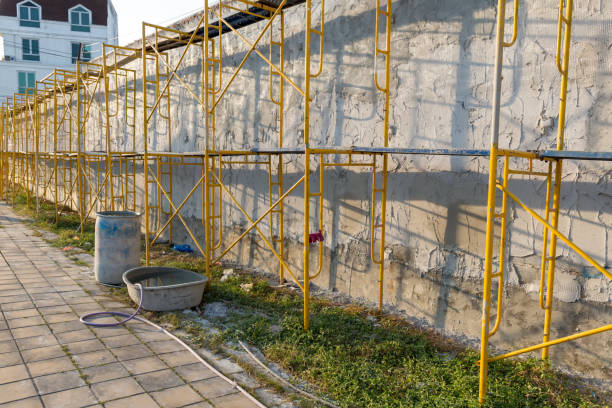 istock Extensive scaffolding providing platforms for work in progress on a new wall block. Modern house wall construction with scaffold pole platform. part of modern scaffolding at a construction site. 1319963035