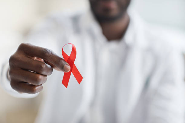 Man holding a red ribbon Close-up of male doctor holding red ribbon aids stock pictures, royalty-free photos & images